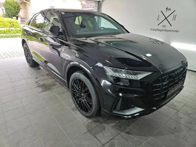 Schwarzer Audi Q8 vor dem Gebäude, an der Wand das Zeichen A mal M mit dem Schriftzug Autopflege Mayerhofer