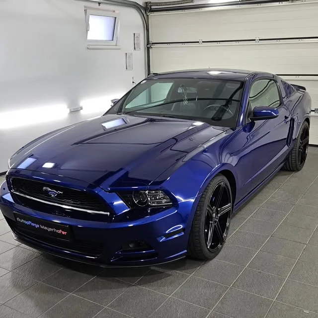 Dunkelblauer Ford Mustang in der Werkstatt, am Kennzeichenhalter der Schriftzug Autopflege Mayerhofer